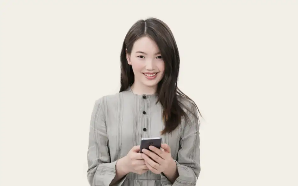Smiling woman holding her phone, showing how Filipino players use 218PLUSPH on mobile