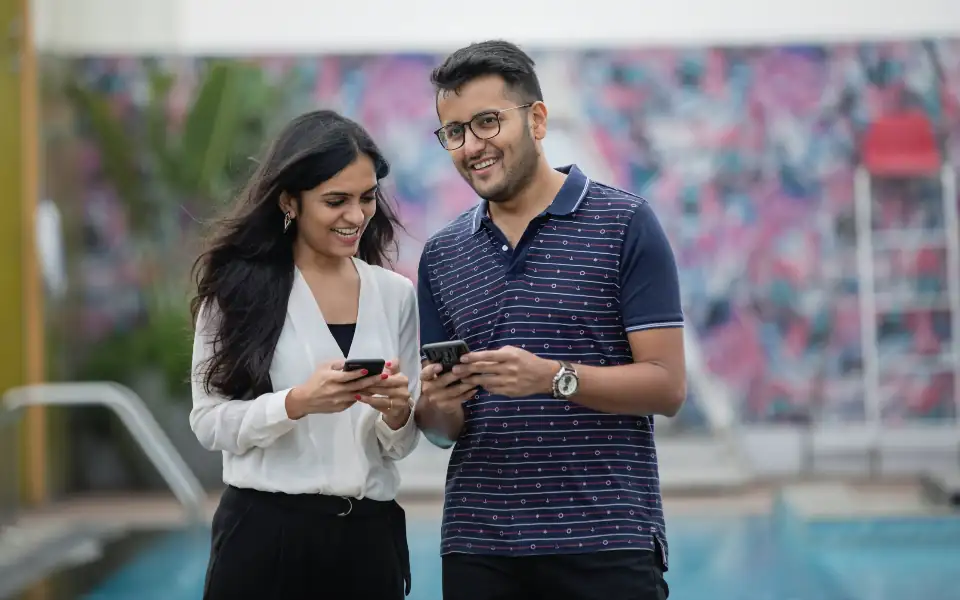 Young Filipino couple using their phones, representing mobile play on 218PLUSPH